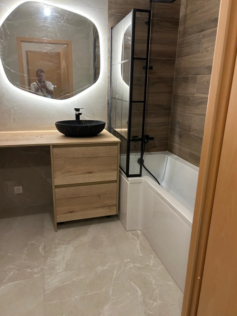 Salle de bain rénovée à Annecy, avec vasque, miroir éclairé et baignoire